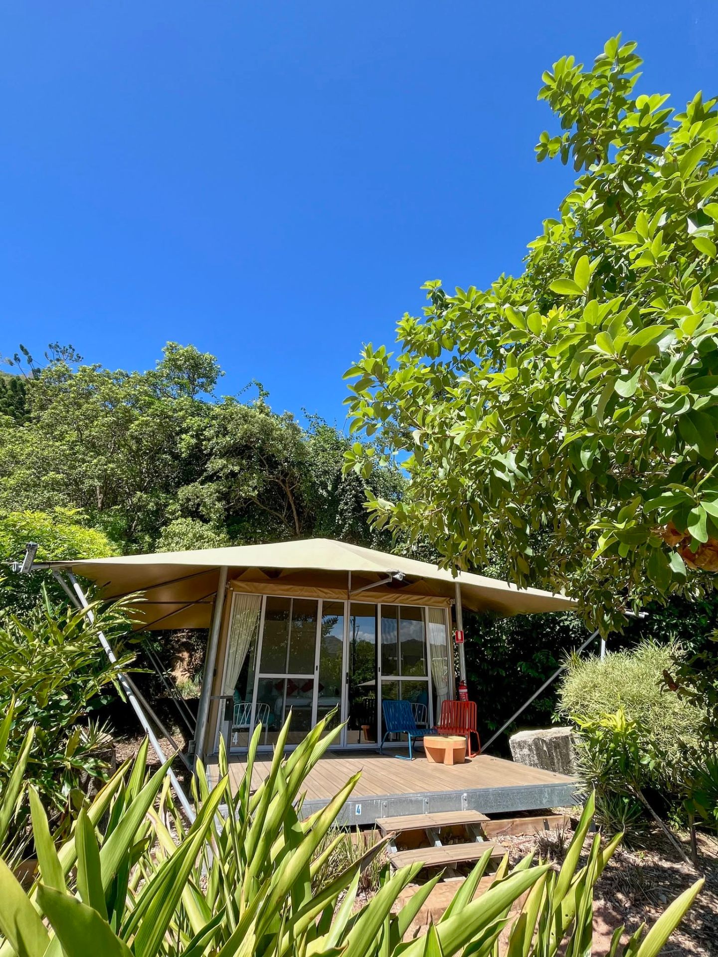 Exterior of a Magnetic Glamping canvas tent nestled in tropical gardens