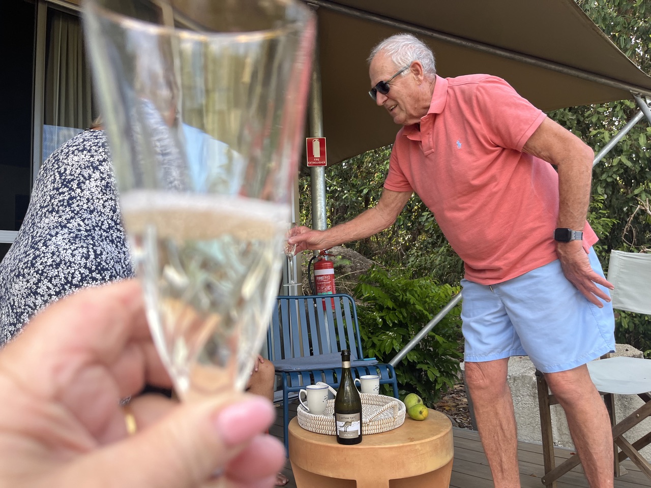 Guests toasting with sparkling wine on their tent deck at Magnetic Glamping
