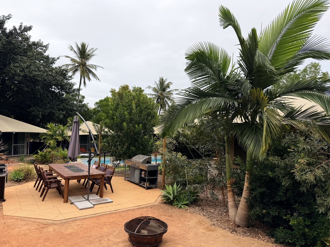 Shared BBQ, outdoor dining table and firepit beside the magnesium pool at Magnetic Glamping