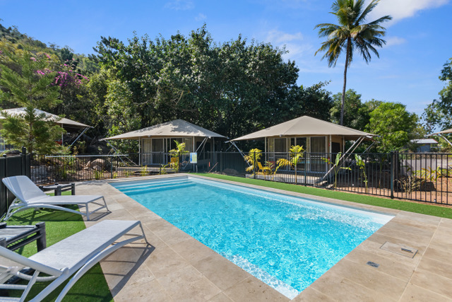 Magnesium pool with safari tents and palms beyond, Magnetic Glamping