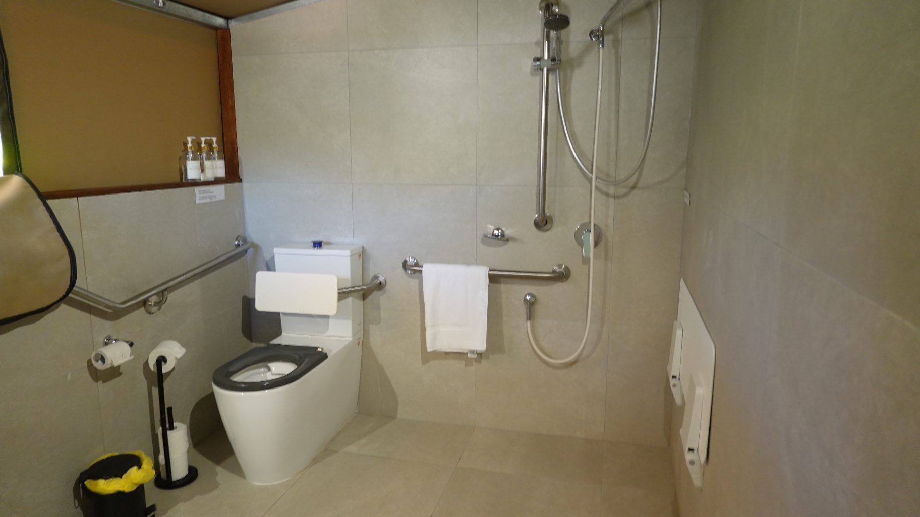 Tent 7 accessible ensuite — wide wet-room shower area with stainless grab rails, Magnetic Glamping