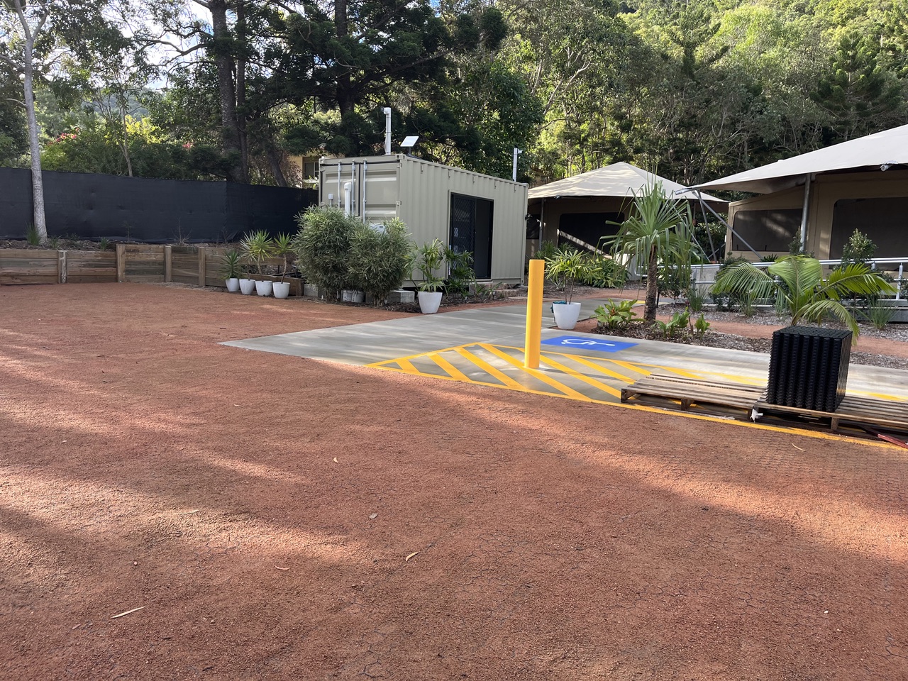 Marked accessible parking bay with level concrete path leading to the tents, Magnetic Glamping